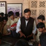 Group of school children on a heritage tour with a guide in an Indian museum.